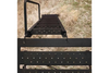 Muddy Elevated hunting box blind made of steel, showcasing a large deer stand with a ladder and a cracked mud camouflage design.